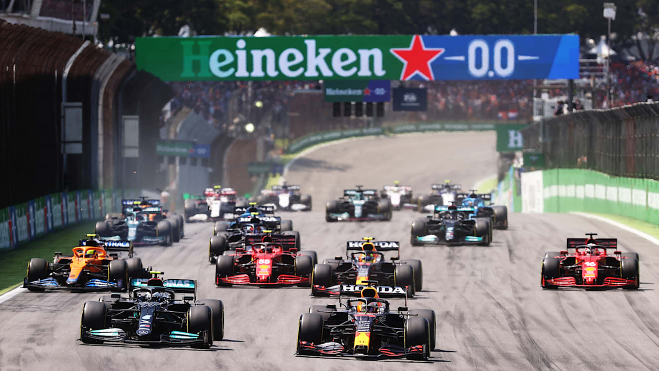 SAO PAULO, BRAZIL - NOVEMBER 14: Max Verstappen of the Netherlands driving the (33) Red Bull Racing RB16B Honda and Valtteri Bottas of Finland driving the (77) Mercedes AMG Petronas F1 Team Mercedes W12 lead the field into turn one at the start during the F1 Grand Prix of Brazil at Autodromo Jose Carlos Pace on November 14, 2021 in Sao Paulo, Brazil. (Photo by Lars Baron/Getty Images)