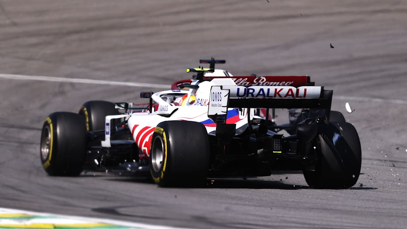 SAO PAULO, BRAZIL - NOVEMBER 14: Mick Schumacher of Germany driving the (47) Haas F1 Team VF-21 Ferrari collides with Kimi Raikkonen of Finland driving the (7) Alfa Romeo Racing C41 Ferrari during the F1 Grand Prix of Brazil at Autodromo Jose Carlos Pace on November 14, 2021 in Sao Paulo, Brazil. (Photo by Lars Baron/Getty Images)