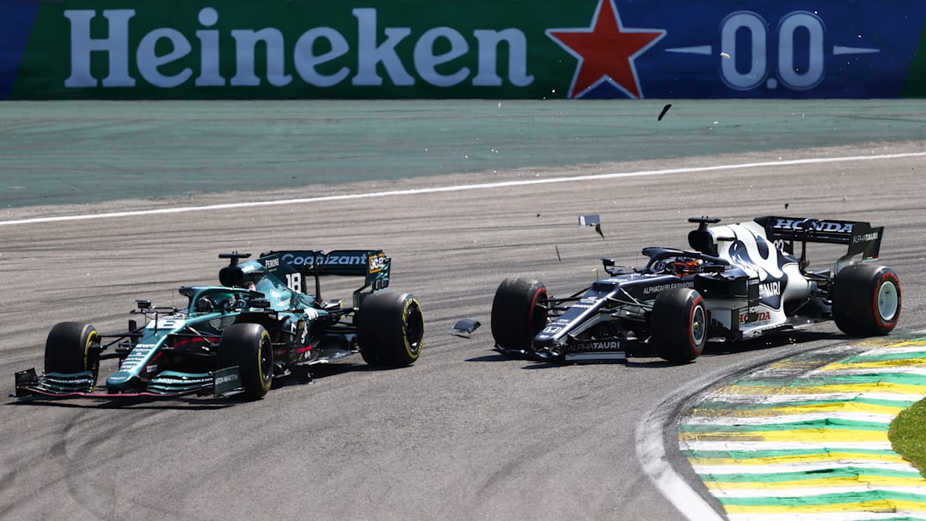 SAO PAULO, BRAZIL - NOVEMBER 14: Yuki Tsunoda of Japan driving the (22) Scuderia AlphaTauri AT02 Honda collides with Lance Stroll of Canada driving the (18) Aston Martin AMR21 Mercedes during the F1 Grand Prix of Brazil at Autodromo Jose Carlos Pace on November 14, 2021 in Sao Paulo, Brazil. (Photo by Bryn Lennon - Formula 1/Formula 1 via Getty Images)