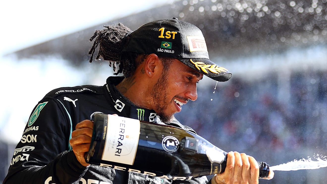 SAO PAULO, BRAZIL - NOVEMBER 14: Race winner Lewis Hamilton of Great Britain and Mercedes GP celebrates on the podium with sparkling wine during the F1 Grand Prix of Brazil at Autodromo Jose Carlos Pace on November 14, 2021 in Sao Paulo, Brazil. (Photo by Bryn Lennon - Formula 1/Formula 1 via Getty Images)