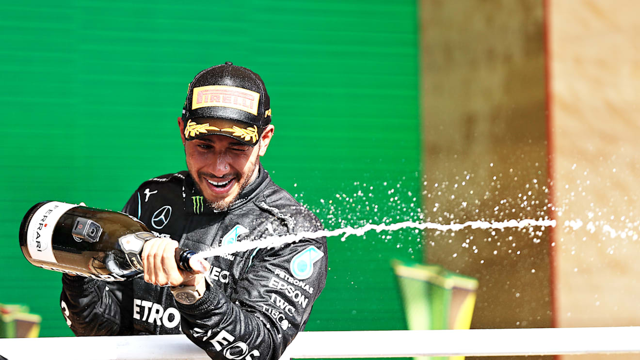 SAO PAULO, BRAZIL - NOVEMBER 14: Race winner Lewis Hamilton of Great Britain and Mercedes GP celebrates on the podium with sparkling wine during the F1 Grand Prix of Brazil at Autodromo Jose Carlos Pace on November 14, 2021 in Sao Paulo, Brazil. (Photo by Buda Mendes/Getty Images)