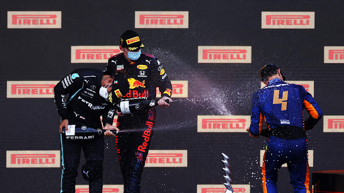 IMOLA, ITALY - APRIL 18: Second placed Lewis Hamilton of Great Britain and Mercedes GP, race winner Max Verstappen of Netherlands and Red Bull Racing and third placed Lando Norris of Great Britain and McLaren F1 celebrate with sparkling wine on the podium during the F1 Grand Prix of Emilia Romagna at Autodromo Enzo e Dino Ferrari on April 18, 2021 in Imola, Italy. (Photo by Lars Baron/Getty Images)