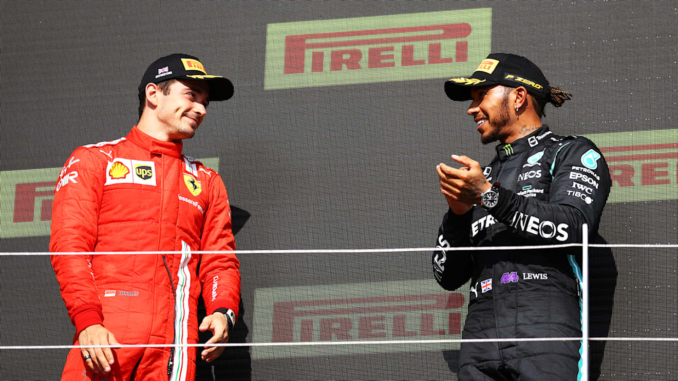 NORTHAMPTON, ENGLAND - JULY 18: Race winner Lewis Hamilton of Great Britain and Mercedes GP and second placed Charles Leclerc of Monaco and Ferrari celebrate on the podium during the F1 Grand Prix of Great Britain at Silverstone on July 18, 2021 in Northampton, England. (Photo by Bryn Lennon - Formula 1/Formula 1 via Getty Images)