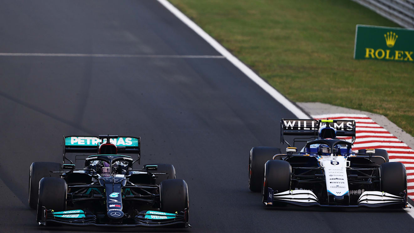 BUDAPEST, HUNGARY - AUGUST 01: Lewis Hamilton of Great Britain driving the (44) Mercedes AMG Petronas F1 Team Mercedes W12 overtakes Nicholas Latifi of Canada driving the (6) Williams Racing FW43B Mercedes during the F1 Grand Prix of Hungary at Hungaroring on August 01, 2021 in Budapest, Hungary. (Photo by Bryn Lennon/Getty Images)