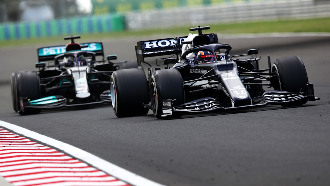BUDAPEST, HUNGARY - AUGUST 01:Yuki Tsunoda of Japan driving the (22) Scuderia AlphaTauri AT02 Honda leads Lewis Hamilton of Great Britain driving the (44) Mercedes AMG Petronas F1 Team Mercedes W12 during the F1 Grand Prix of Hungary at Hungaroring on August 01, 2021 in Budapest, Hungary. (Photo by Joe Portlock - Formula 1/Formula 1 via Getty Images)