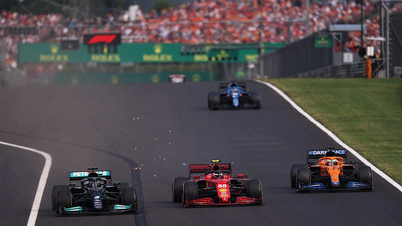 BUDAPEST, HUNGARY - AUGUST 01: Lewis Hamilton of Great Britain driving the (44) Mercedes AMG Petronas F1 Team Mercedes W12 overtakes Carlos Sainz of Spain driving the (55) Scuderia Ferrari SF21 for third place during the F1 Grand Prix of Hungary at Hungaroring on August 01, 2021 in Budapest, Hungary. (Photo by Lars Baron/Getty Images)
