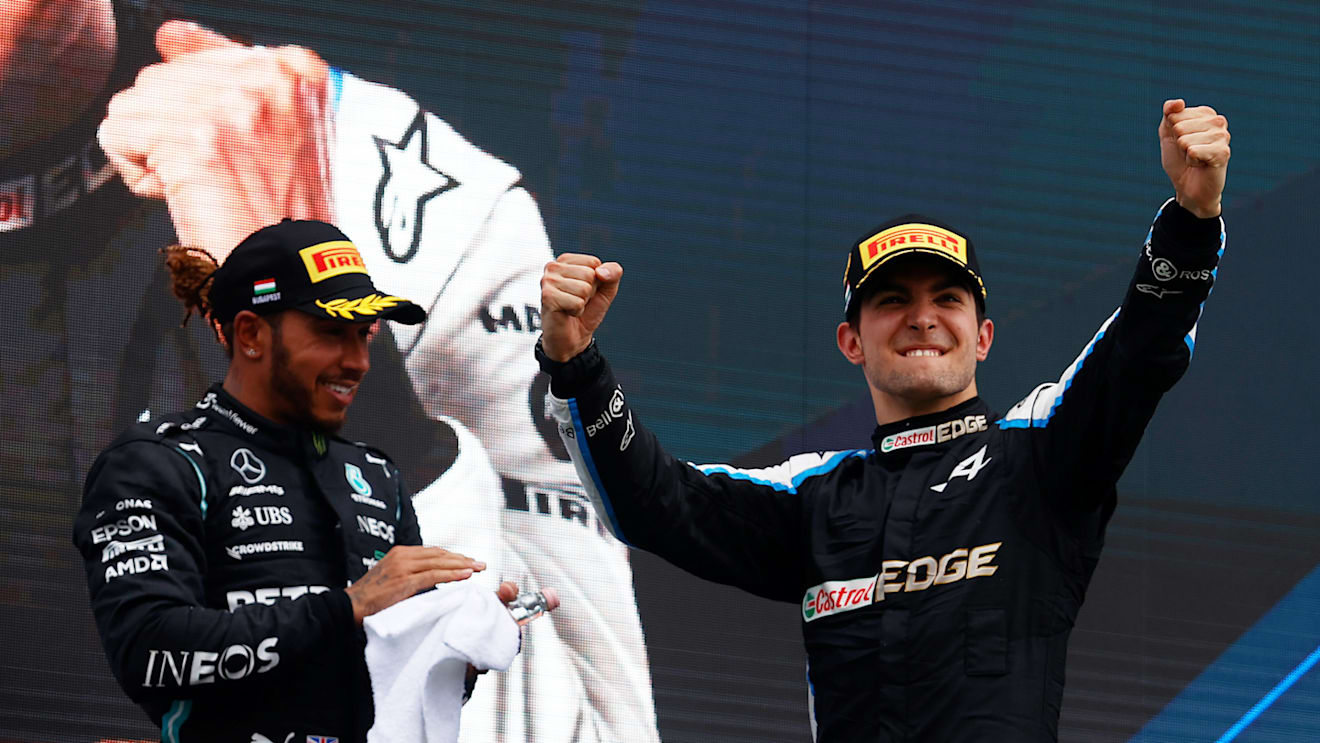 BUDAPEST, HUNGARY - AUGUST 01: Race winner Esteban Ocon of France and Alpine F1 Team celebrates on the podium next to third placed Lewis Hamilton of Great Britain and Mercedes GP during the F1 Grand Prix of Hungary at Hungaroring on August 01, 2021 in Budapest, Hungary. (Photo by Florion Goga - Pool/Getty Images)
