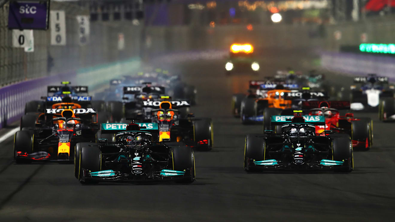 JEDDAH, SAUDI ARABIA - DECEMBER 05: Lewis Hamilton of Great Britain driving the (44) Mercedes AMG Petronas F1 Team Mercedes W12 leads Valtteri Bottas of Finland driving the (77) Mercedes AMG Petronas F1 Team Mercedes W12 and the rest of the field into turn one at the start during the F1 Grand Prix of Saudi Arabia at Jeddah Corniche Circuit on December 05, 2021 in Jeddah, Saudi Arabia. (Photo by Joe Portlock - Formula 1/Formula 1 via Getty Images)