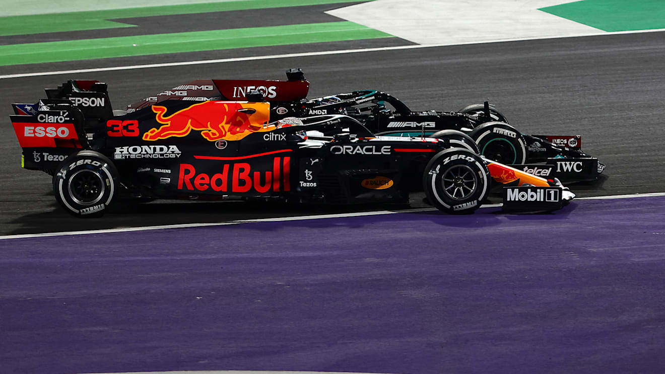 JEDDAH, SAUDI ARABIA - DECEMBER 05: Max Verstappen of the Netherlands driving the (33) Red Bull Racing RB16B Honda and Lewis Hamilton of Great Britain driving the (44) Mercedes AMG Petronas F1 Team Mercedes W12 battle for track position at the restart during the F1 Grand Prix of Saudi Arabia at Jeddah Corniche Circuit on December 05, 2021 in Jeddah, Saudi Arabia. (Photo by Mark Thompson/Getty Images)