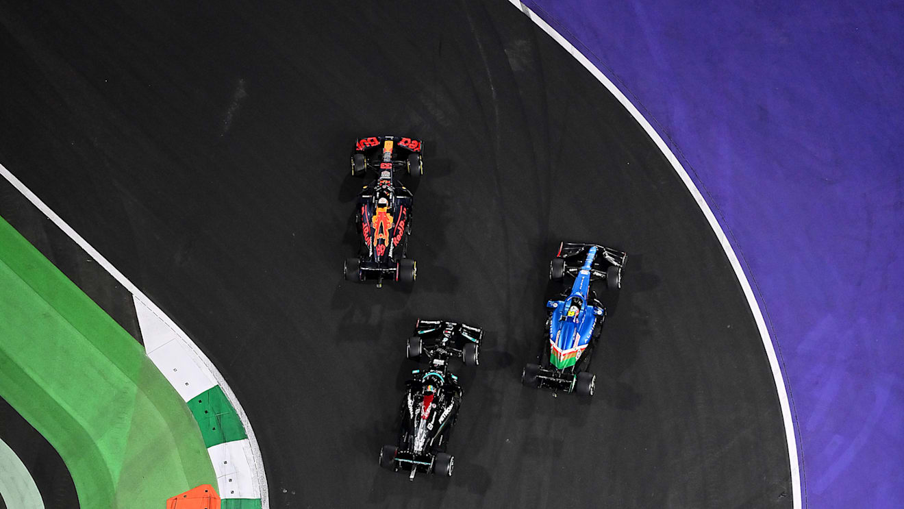 JEDDAH, SAUDI ARABIA - DECEMBER 05: Max Verstappen of the Netherlands driving the (33) Red Bull Racing RB16B Honda leads the field into turn one ahead of Lewis Hamilton of Great Britain driving the (44) Mercedes AMG Petronas F1 Team Mercedes W12 and Esteban Ocon of France driving the (31) Alpine A521 Renault at the second restart during the F1 Grand Prix of Saudi Arabia at Jeddah Corniche Circuit on December 05, 2021 in Jeddah, Saudi Arabia. (Photo by Dan Mullan/Getty Images)