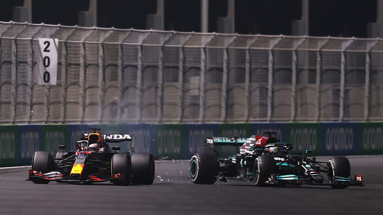 JEDDAH, SAUDI ARABIA - DECEMBER 05: Max Verstappen of the Netherlands driving the (33) Red Bull Racing RB16B Honda and Lewis Hamilton of Great Britain driving the (44) Mercedes AMG Petronas F1 Team Mercedes W12 collide during the F1 Grand Prix of Saudi Arabia at Jeddah Corniche Circuit on December 05, 2021 in Jeddah, Saudi Arabia. (Photo by Lars Baron/Getty Images)