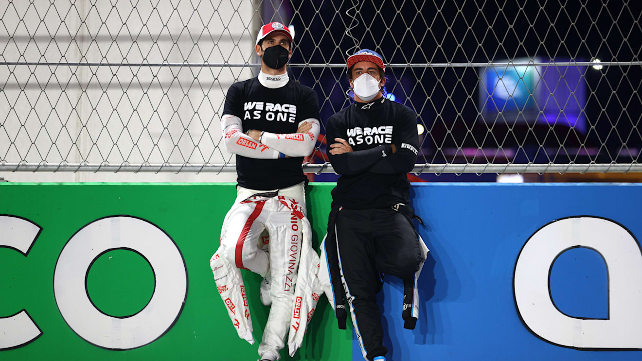 JEDDAH, SAUDI ARABIA - DECEMBER 05: Antonio Giovinazzi of Italy and Alfa Romeo Racing and Fernando Alonso of Spain and Alpine F1 Team talk on the grid before the F1 Grand Prix of Saudi Arabia at Jeddah Corniche Circuit on December 05, 2021 in Jeddah, Saudi Arabia. (Photo by Bryn Lennon - Formula 1/Formula 1 via Getty Images)