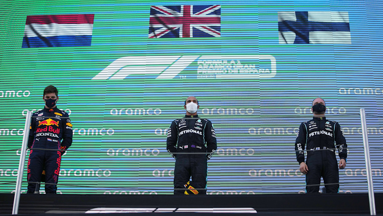BARCELONA, SPAIN - MAY 09: Second placed Max Verstappen of Netherlands and Red Bull Racing, race winner Lewis Hamilton of Great Britain and Mercedes GP and third placed Valtteri Bottas of Finland and Mercedes GP stand on the podium during the F1 Grand Prix of Spain at Circuit de Barcelona-Catalunya on May 09, 2021 in Barcelona, Spain. (Photo by Emilio Morenatti - Pool/Getty Images)