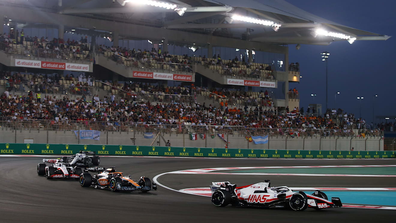 ABU DHABI, UNITED ARAB EMIRATES - NOVEMBER 20: Kevin Magnussen of Denmark driving the (20) Haas F1 VF-22 Ferrari leads Daniel Ricciardo of Australia driving the (3) McLaren MCL36 Mercedes and Mick Schumacher of Germany driving the (47) Haas F1 VF-22 Ferrari on track during the F1 Grand Prix of Abu Dhabi at Yas Marina Circuit on November 20, 2022 in Abu Dhabi, United Arab Emirates. (Photo by Joe Portlock - Formula 1/Formula 1 via Getty Images)