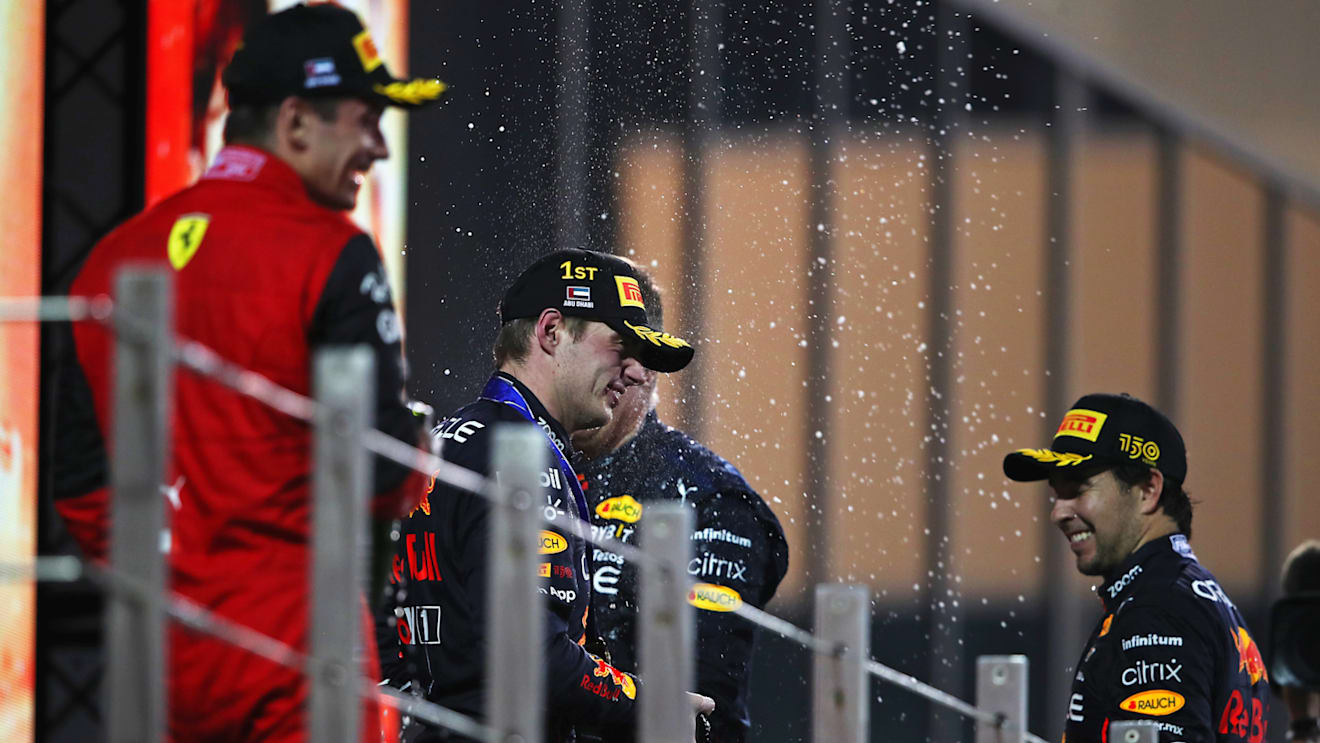 ABU DHABI, UNITED ARAB EMIRATES - NOVEMBER 20: Race winner Max Verstappen of the Netherlands and Oracle Red Bull Racing, Second placed Charles Leclerc of Monaco and Ferrari and Third placed Sergio Perez of Mexico and Oracle Red Bull Racing celebrate on the podium during the F1 Grand Prix of Abu Dhabi at Yas Marina Circuit on November 20, 2022 in Abu Dhabi, United Arab Emirates. (Photo by Joe Portlock - Formula 1/Formula 1 via Getty Images)