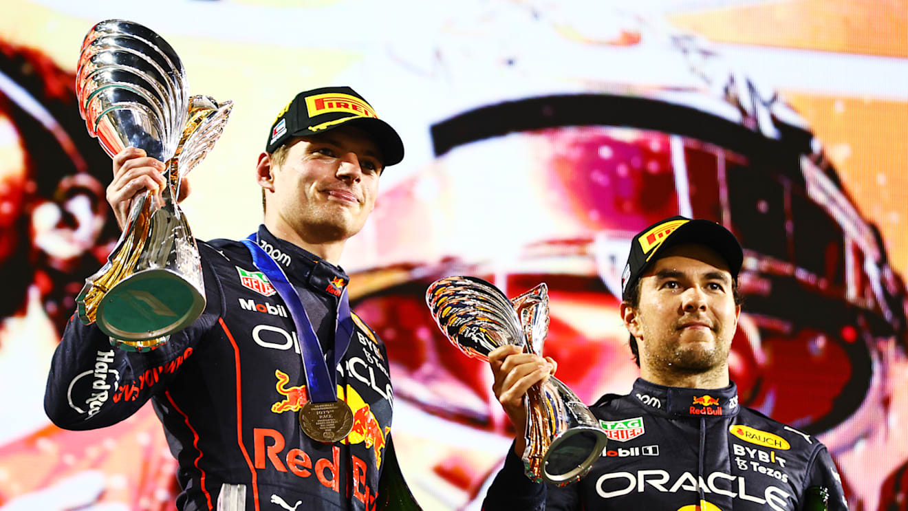 ABU DHABI, UNITED ARAB EMIRATES - NOVEMBER 20: Race Winner Max Verstappen of the Netherlands and Oracle Red Bull Racing and Third placed Sergio Perez of Mexico and Oracle Red Bull Racing celebrate on the podium during the F1 Grand Prix of Abu Dhabi at Yas Marina Circuit on November 20, 2022 in Abu Dhabi, United Arab Emirates. (Photo by Mark Thompson/Getty Images)