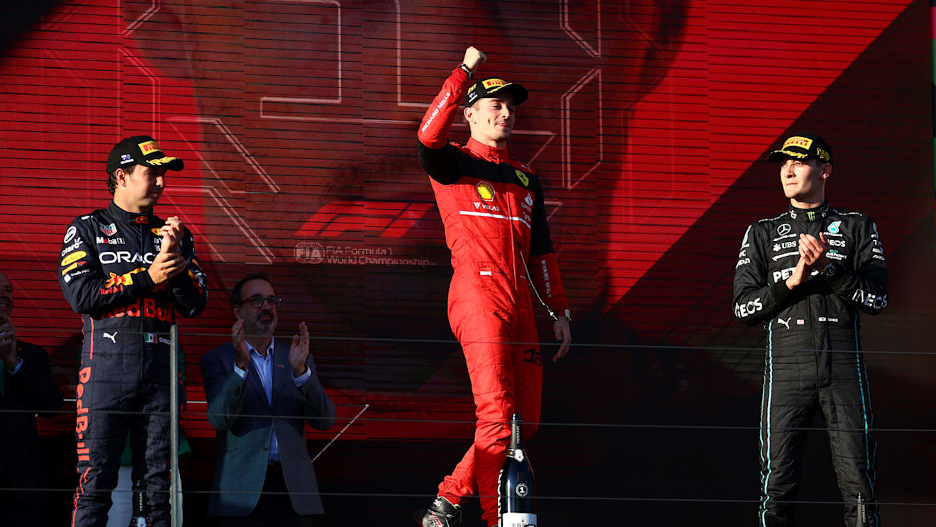 MELBOURNE, AUSTRALIA - APRIL 10: Race winner Charles Leclerc of Monaco and Ferrari celebrates on the podium next to Second placed Sergio Perez of Mexico and Oracle Red Bull Racing and Third placed George Russell of Great Britain and Mercedes during the F1 Grand Prix of Australia at Melbourne Grand Prix Circuit on April 10, 2022 in Melbourne, Australia. (Photo by Bryn Lennon - Formula 1/Formula 1 via Getty Images)