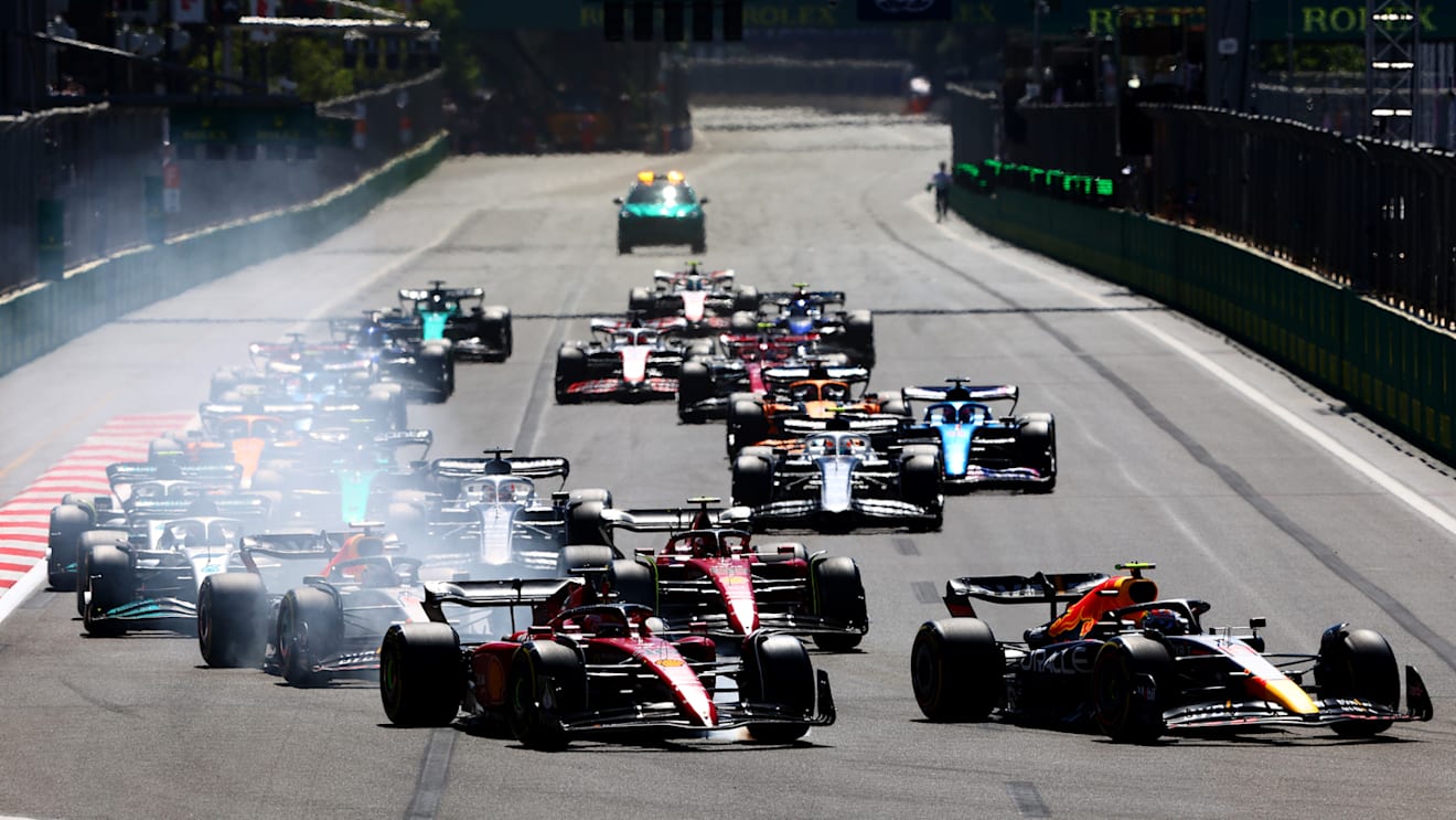 BAKU, AZERBAIJAN - JUNE 12: Sergio Perez of Mexico driving the (11) Oracle Red Bull Racing RB18 leads Charles Leclerc of Monaco driving the (16) Ferrari F1-75 and the rest of the field into turn one at the start during the F1 Grand Prix of Azerbaijan at Baku City Circuit on June 12, 2022 in Baku, Azerbaijan. (Photo by Mark Thompson/Getty Images)