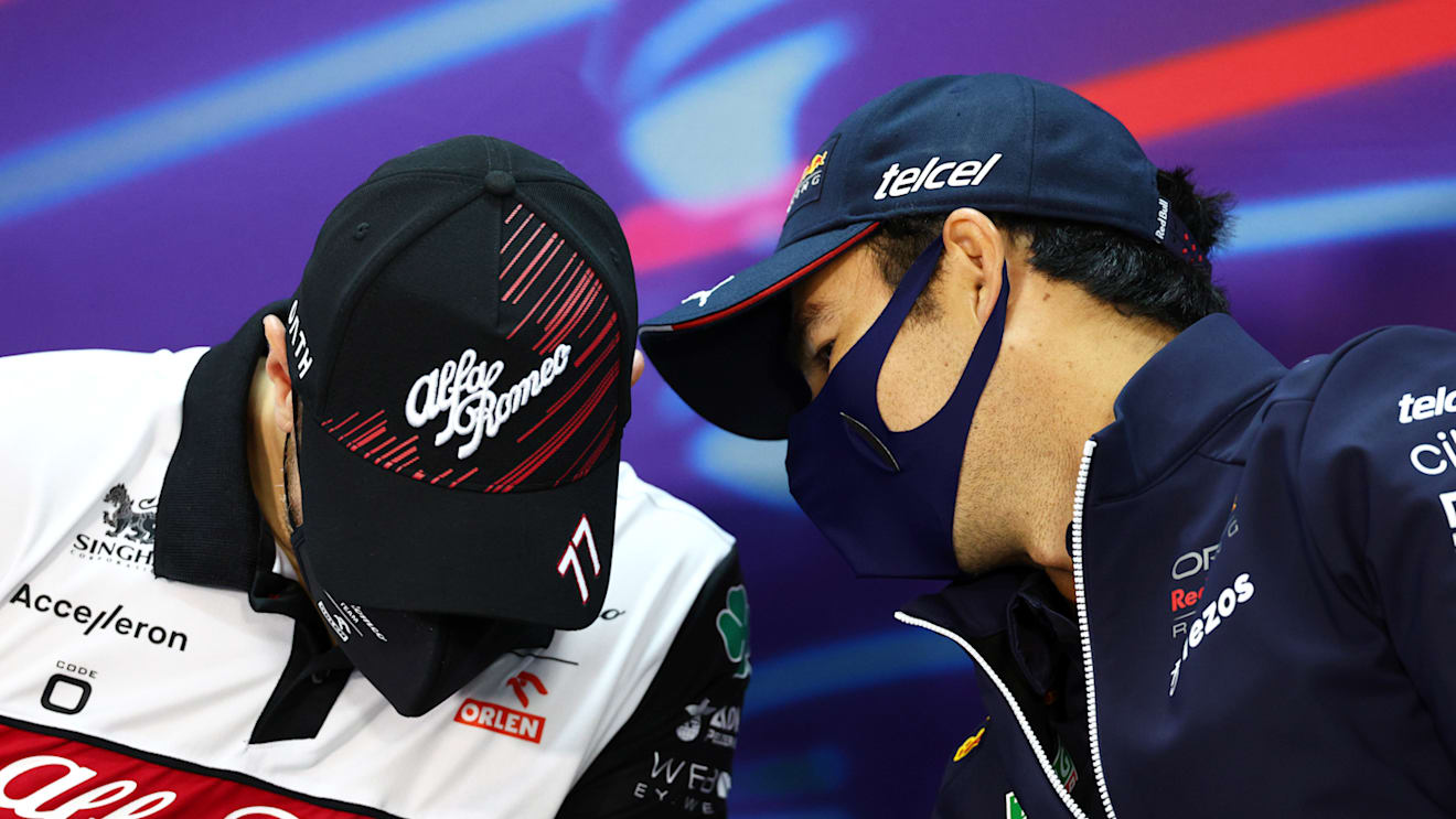 BAHRAIN, BAHRAIN - MARCH 18: Sergio Perez of Mexico and Oracle Red Bull Racing talks with Valtteri Bottas of Finland and Alfa Romeo F1 in the Drivers Press Conference before practice ahead of the F1 Grand Prix of Bahrain at Bahrain International Circuit on March 18, 2022 in Bahrain, Bahrain. (Photo by Clive Rose/Getty Images)