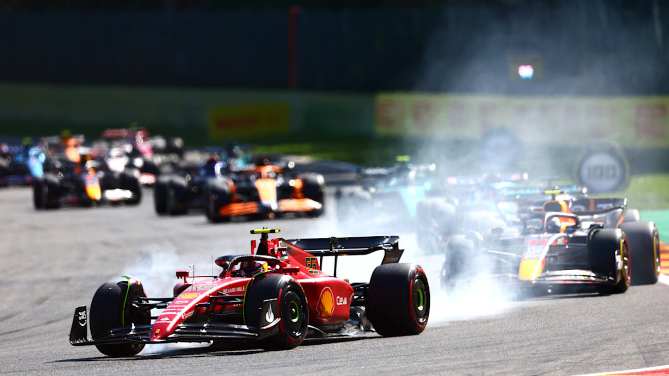SPA, BELGIUM - AUGUST 28: Carlos Sainz of Spain driving (55) the Ferrari F1-75 locks a wheel under braking ahead of Sergio Perez of Mexico driving the (11) Oracle Red Bull Racing RB18 during the F1 Grand Prix of Belgium at Circuit de Spa-Francorchamps on August 28, 2022 in Spa, Belgium. (Photo by Dan Istitene - Formula 1/Formula 1 via Getty Images)