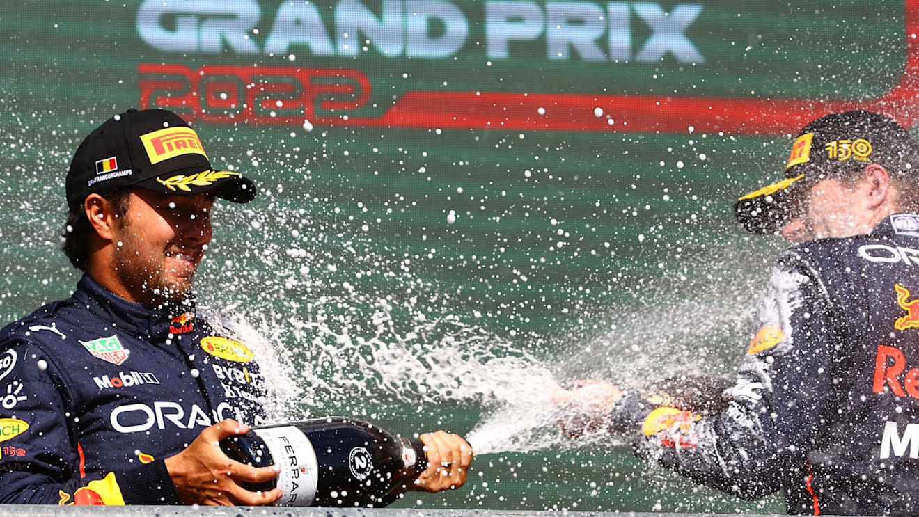 SPA, BELGIUM - AUGUST 28: Race winner Max Verstappen of the Netherlands and Oracle Red Bull Racing and Second placed Sergio Perez of Mexico and Oracle Red Bull Racing celebrate on the podium during the F1 Grand Prix of Belgium at Circuit de Spa-Francorchamps on August 28, 2022 in Spa, Belgium. (Photo by Mark Thompson/Getty Images)