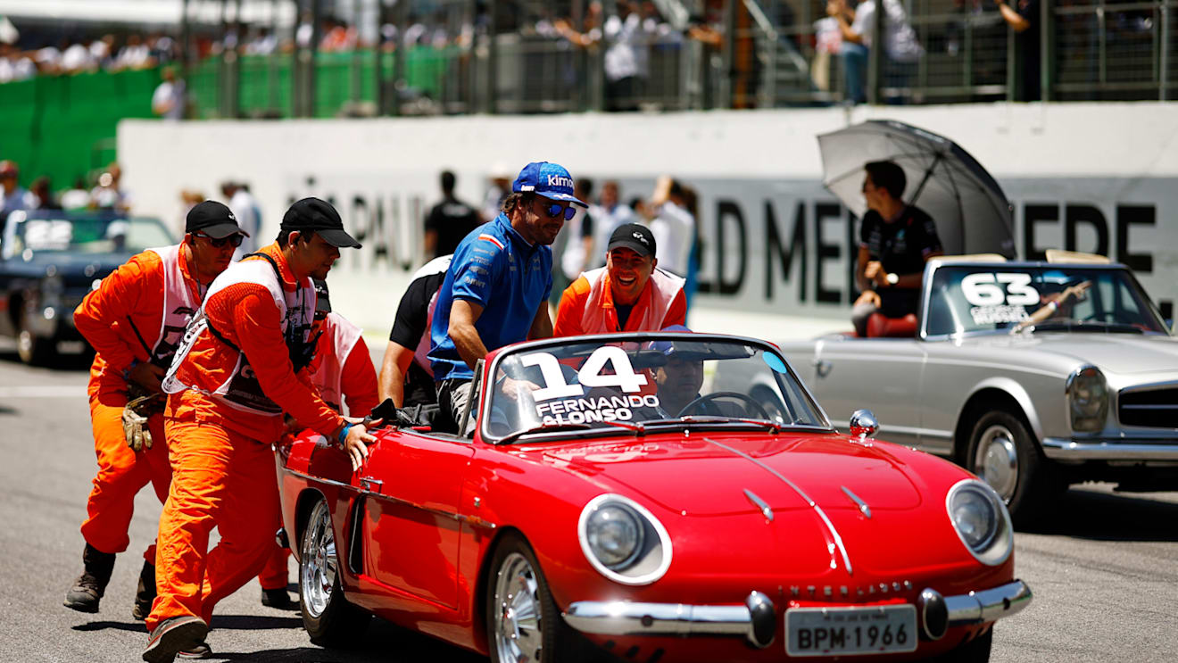 SAO PAULO, BRAZIL - NOVEMBER 13: Track marshals help Fernando Alonso of Spain and Alpine F1 as his car stops on the drivers parade prior to the F1 Grand Prix of Brazil at Autodromo Jose Carlos Pace on November 13, 2022 in Sao Paulo, Brazil. (Photo by Chris Graythen/Getty Images)