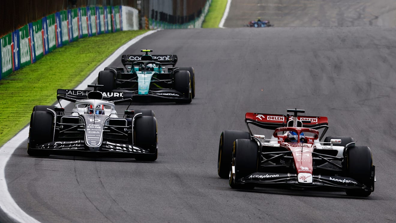SAO PAULO, BRAZIL - NOVEMBER 13: Pierre Gasly of France driving the (10) Scuderia AlphaTauri AT03 anf Valtteri Bottas of Finland driving the (77) Alfa Romeo F1 C42 Ferrari battle for track position during the F1 Grand Prix of Brazil at Autodromo Jose Carlos Pace on November 13, 2022 in Sao Paulo, Brazil. (Photo by Chris Graythen/Getty Images)