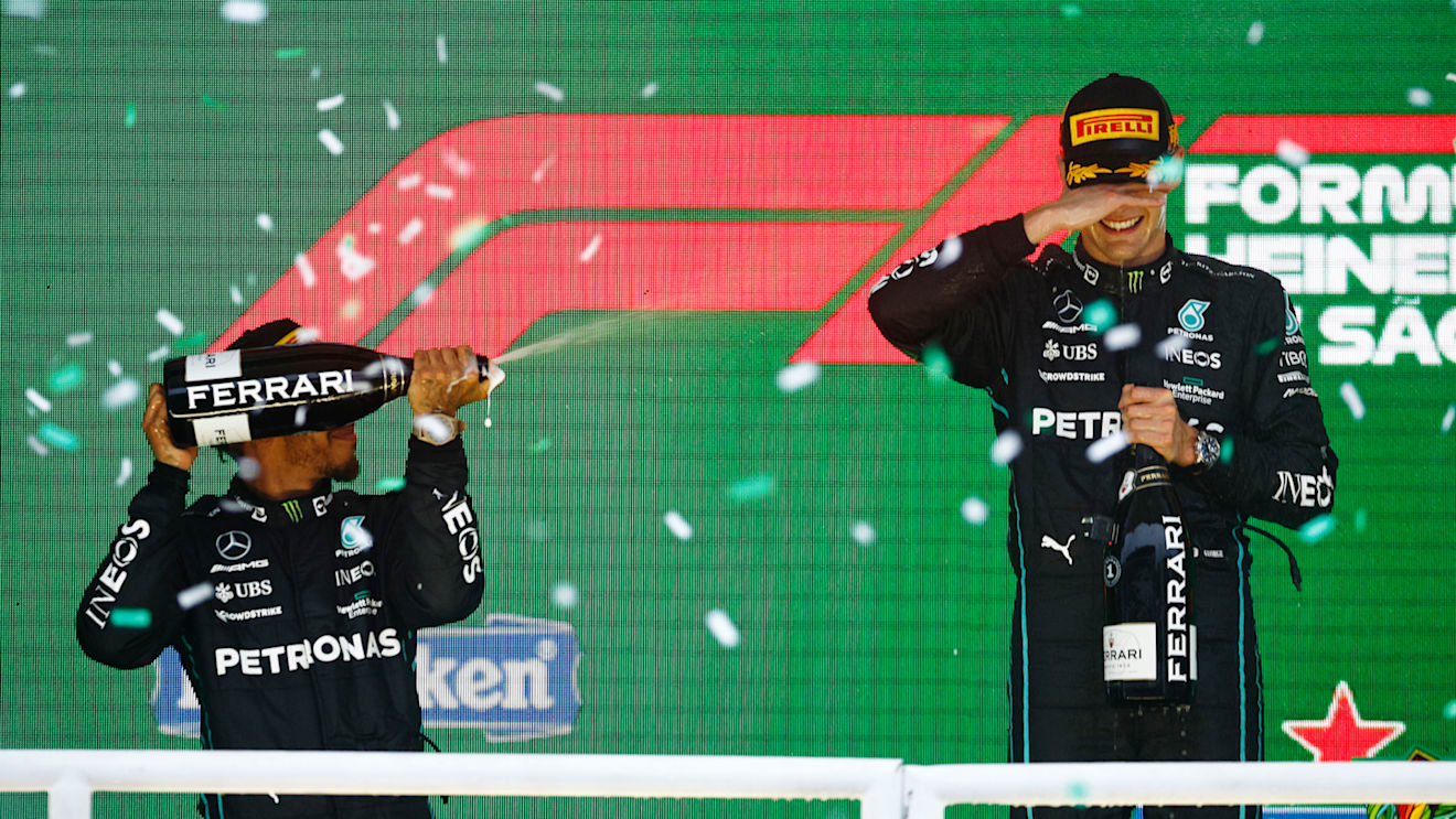 SAO PAULO, BRAZIL - NOVEMBER 13: Race winner George Russell of Great Britain and Mercedes and Second placed Lewis Hamilton of Great Britain and Mercedes celebrate on the podium during the F1 Grand Prix of Brazil at Autodromo Jose Carlos Pace on November 13, 2022 in Sao Paulo, Brazil. (Photo by Chris Graythen/Getty Images)