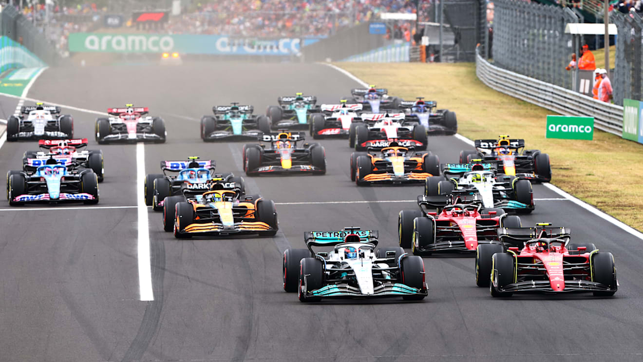 BUDAPEST, HUNGARY - JULY 31: George Russell of Great Britain driving the (63) Mercedes AMG Petronas F1 Team W13 and Carlos Sainz of Spain driving (55) the Ferrari F1-75 battle for track position ahead of the field into turn one at the start during the F1 Grand Prix of Hungary at Hungaroring on July 31, 2022 in Budapest, Hungary. (Photo by Mark Thompson/Getty Images)