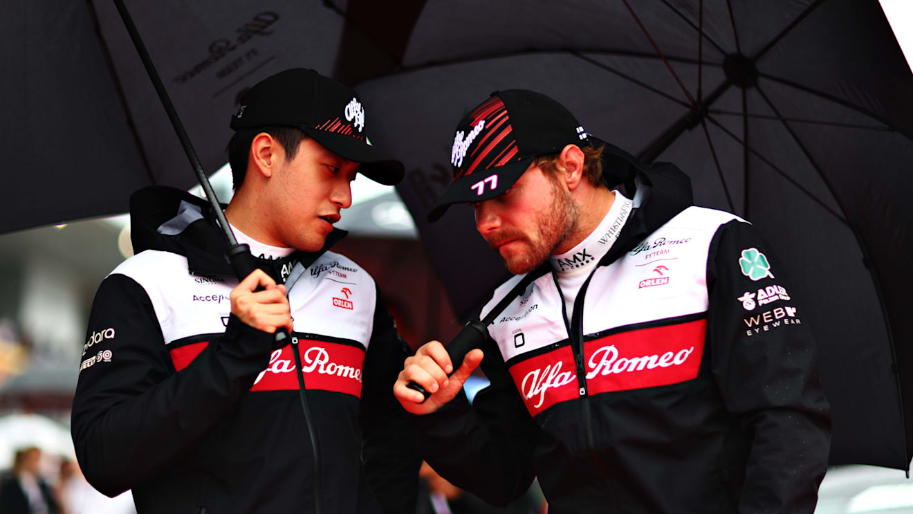 SUZUKA, JAPAN - OCTOBER 09: Zhou Guanyu of China and Alfa Romeo F1 and Valtteri Bottas of Finland and Alfa Romeo F1 talk on from the grid during the F1 Grand Prix of Japan at Suzuka International Racing Course on October 09, 2022 in Suzuka, Japan. (Photo by Dan Istitene - Formula 1/Formula 1 via Getty Images)