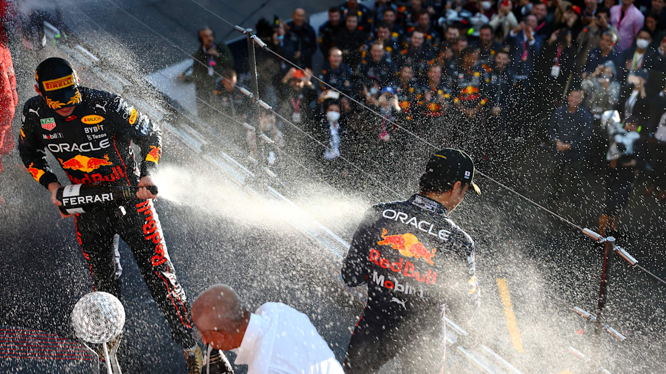 SUZUKA, JAPAN - OCTOBER 09: Race winner and 2022 F1 World Drivers Champion Max Verstappen of Netherlands and Oracle Red Bull Racing and Second placed Sergio Perez of Mexico and Oracle Red Bull Racing celebrate on the podium during the F1 Grand Prix of Japan at Suzuka International Racing Course on October 09, 2022 in Suzuka, Japan. (Photo by Mark Thompson/Getty Images )
