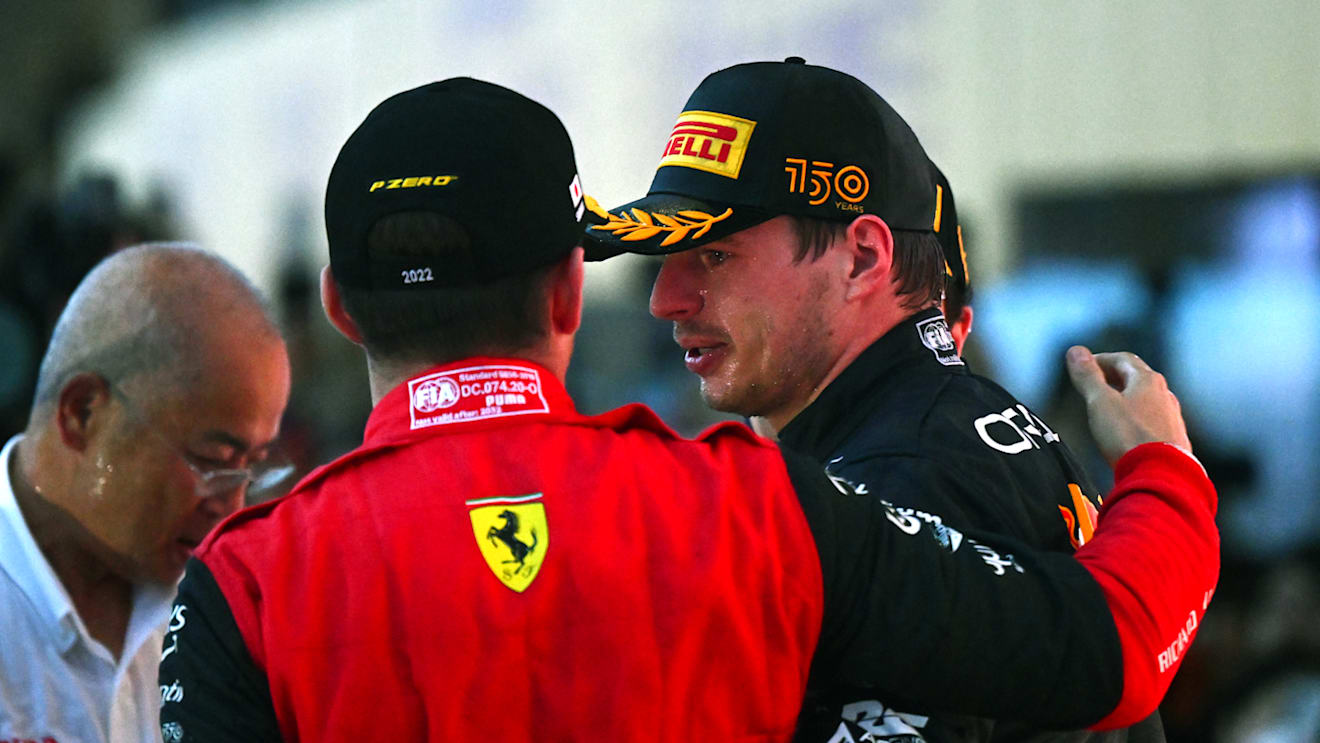 SUZUKA, JAPAN - OCTOBER 09: Race winner and 2022 F1 World Drivers Champion Max Verstappen of Netherlands and Oracle Red Bull Racing and Third placed Charles Leclerc of Monaco and Ferrari celebrate on the podium during the F1 Grand Prix of Japan at Suzuka International Racing Course on October 09, 2022 in Suzuka, Japan. (Photo by Clive Mason/Getty Images)