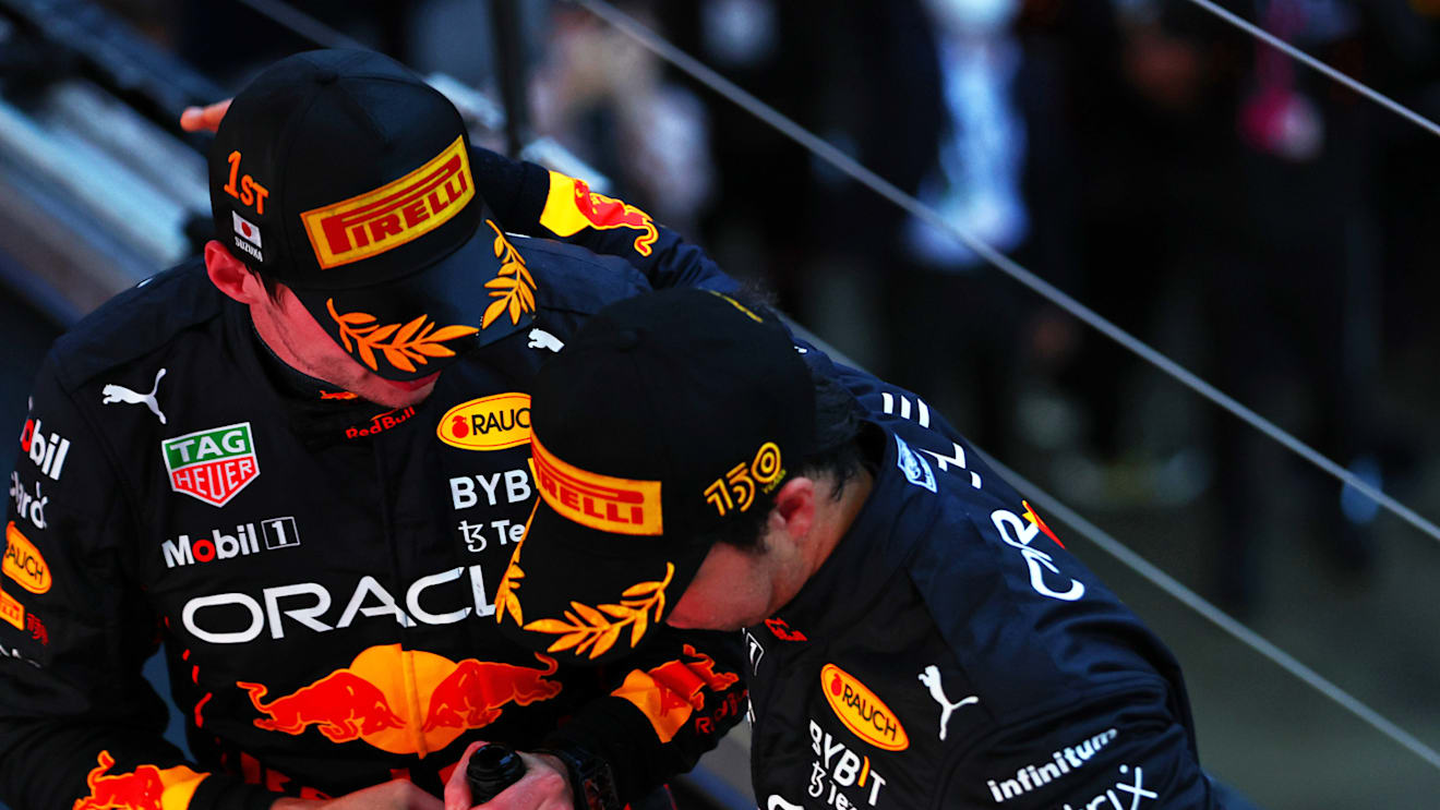 SUZUKA, JAPAN - OCTOBER 09: Race winner and 2022 F1 World Drivers Champion Max Verstappen of Netherlands and Oracle Red Bull Racing and Second placed Sergio Perez of Mexico and Oracle Red Bull Racing celebrate on the podium during the F1 Grand Prix of Japan at Suzuka International Racing Course on October 09, 2022 in Suzuka, Japan. (Photo by Mark Thompson/Getty Images )