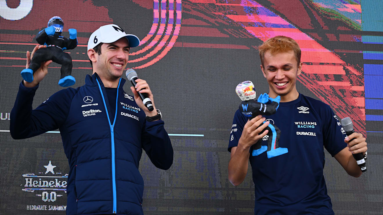 MEXICO CITY, MEXICO - OCTOBER 29: Nicholas Latifi of Canada and Williams and Alexander Albon of Thailand and Williams are presented with figurines made in their likeness on the fan stage prior to final practice ahead of the F1 Grand Prix of Mexico at Autodromo Hermanos Rodriguez on October 29, 2022 in Mexico City, Mexico. (Photo by Clive Mason - Formula 1/Formula 1 via Getty Images)