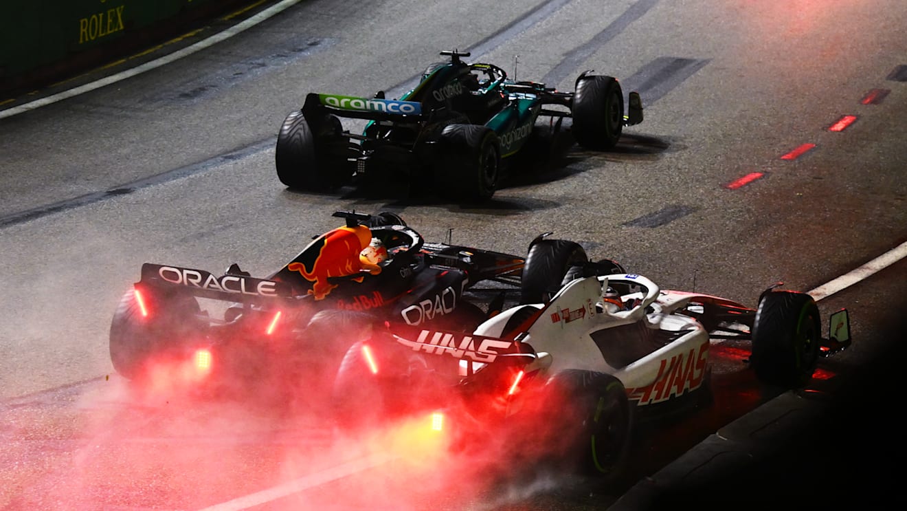 SINGAPORE, SINGAPORE - OCTOBER 02: Max Verstappen of the Netherlands driving the (1) Oracle Red Bull Racing RB18 and Kevin Magnussen of Denmark driving the (20) Haas F1 VF-22 Ferrari battle for track position during the F1 Grand Prix of Singapore at Marina Bay Street Circuit on October 02, 2022 in Singapore, Singapore. (Photo by Clive Mason/Getty Images,)