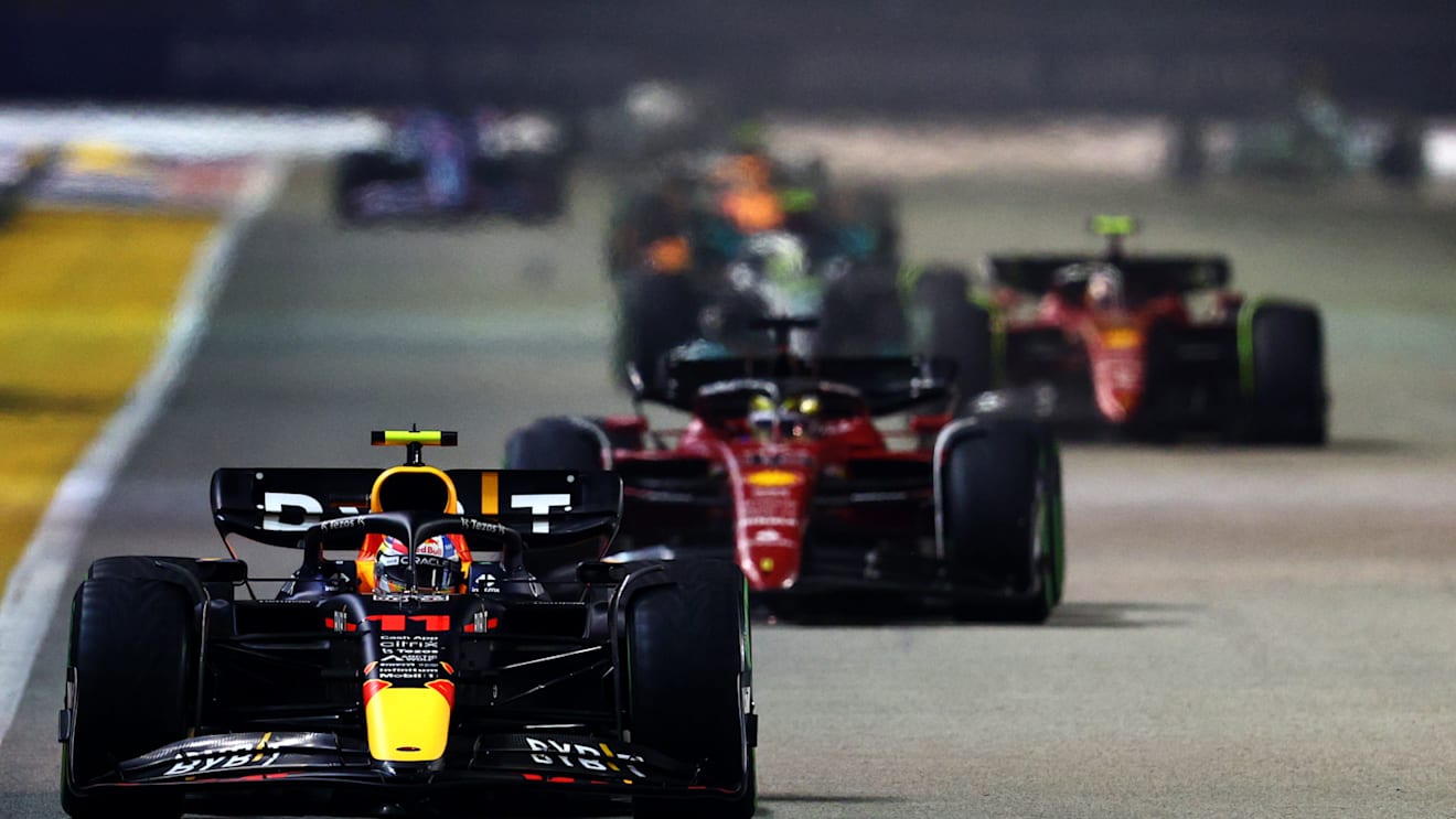 SINGAPORE, SINGAPORE - OCTOBER 02: Sergio Perez of Mexico driving the (11) Oracle Red Bull Racing RB18 leads Charles Leclerc of Monaco driving the (16) Ferrari F1-75 during the F1 Grand Prix of Singapore at Marina Bay Street Circuit on October 02, 2022 in Singapore, Singapore. (Photo by Clive Rose/Getty Images,)