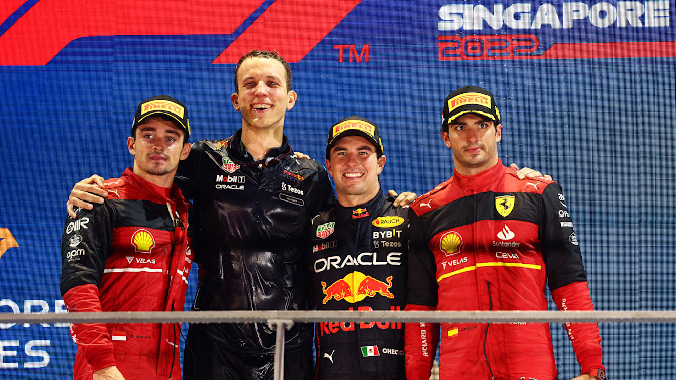 SINGAPORE, SINGAPORE - OCTOBER 02: Race winner Sergio Perez of Mexico and Oracle Red Bull Racing (second from right), Second placed Charles Leclerc of Monaco and Ferrari (L), Third placed Carlos Sainz of Spain and Ferrari (R) and Red Bull Racing race engineer Hugh Bird (second from left) celebrate on the podium during the F1 Grand Prix of Singapore at Marina Bay Street Circuit on October 02, 2022 in Singapore, Singapore. (Photo by Clive Rose/Getty Images,)