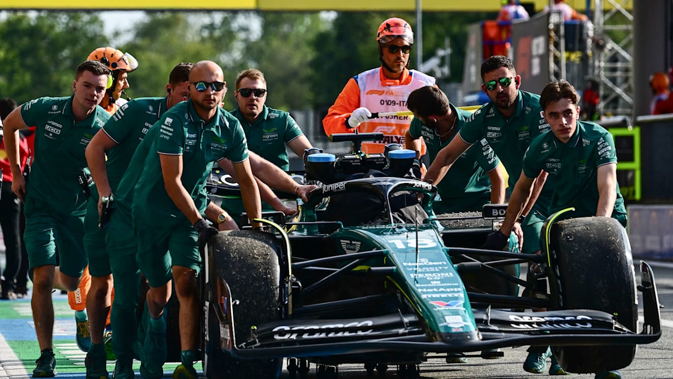 Mechanics run back Aston Martin's Canadian driver Lance Stroll's car in the pit area after a crash during the second practice session, ahead of the Italian Formula One Grand Prix at Autodromo Nazionale Monza circuit, in Monza on September 1, 2023. (Photo by Ben Stansall / AFP) (Photo by BEN STANSALL/AFP via Getty Images)