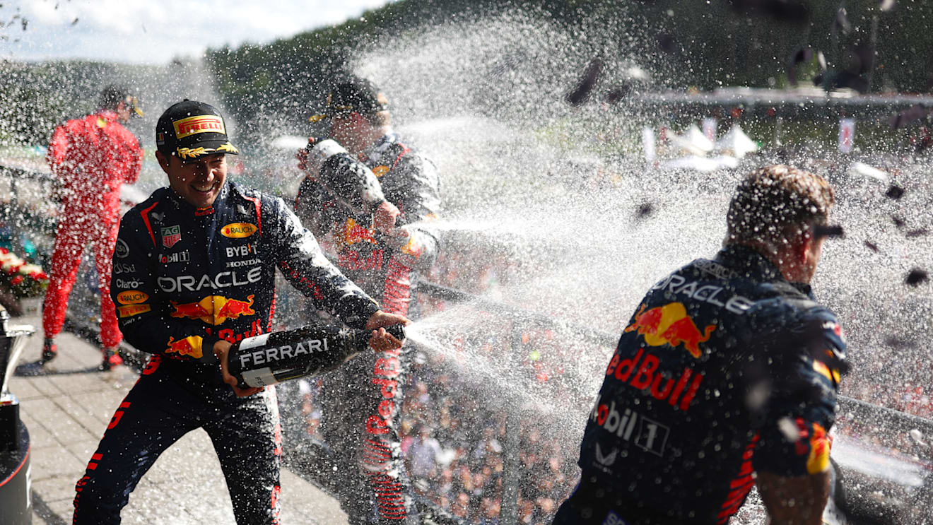 SPA, BELGIUM - JULY 30: Race winner Max Verstappen of the Netherlands and Oracle Red Bull Racing, Second placed Sergio Perez of Mexico and Oracle Red Bull Racing and Greg Reeson, Tyre Technician at Red Bull Racing celebrate on the podium during the F1 Grand Prix of Belgium at Circuit de Spa-Francorchamps on July 30, 2023 in Spa, Belgium. (Photo by Dan Istitene - Formula 1/Formula 1 via Getty Images)
