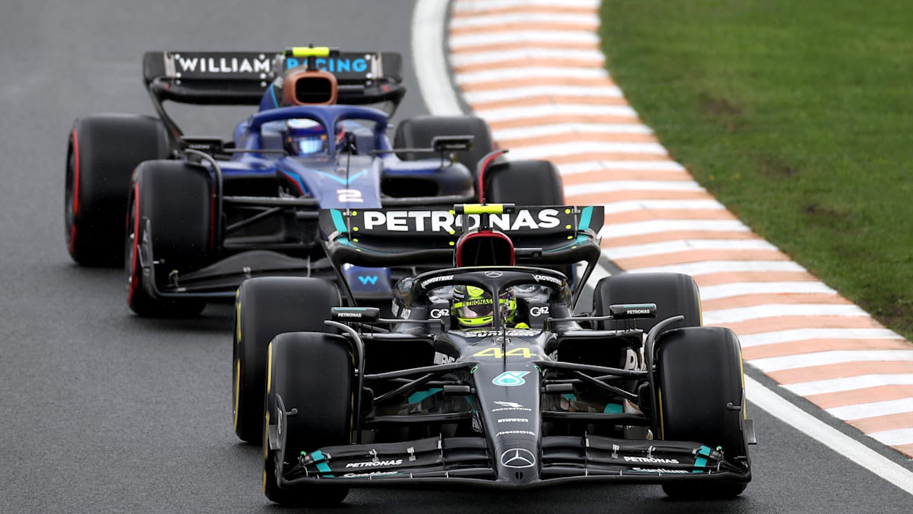 ZANDVOORT, NETHERLANDS - AUGUST 27: Lewis Hamilton of Great Britain driving the (44) Mercedes AMG Petronas F1 Team W14 leads Logan Sargeant of United States driving the (2) Williams FW45 Mercedes during the F1 Grand Prix of The Netherlands at Circuit Zandvoort on August 27, 2023 in Zandvoort, Netherlands. (Photo by Lars Baron/Getty Images)