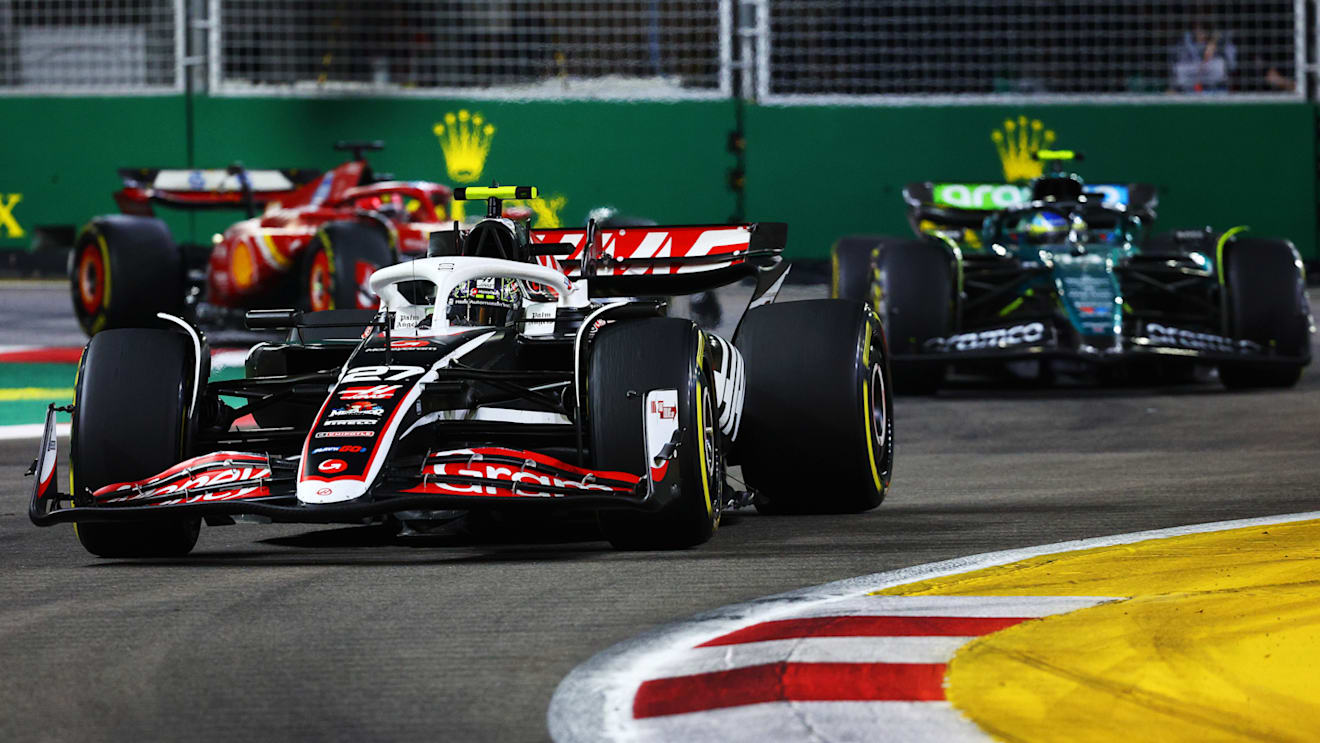 SINGAPORE, SINGAPORE - SEPTEMBER 22: Nico Hulkenberg of Germany driving the (27) Haas F1 VF-24 Ferrari leads Fernando Alonso of Spain driving the (14) Aston Martin AMR24 Mercedes on track during the F1 Grand Prix of Singapore at Marina Bay Street Circuit on September 22, 2024 in Singapore, Singapore. (Photo by Clive Rose - Formula 1/Formula 1 via Getty Images)