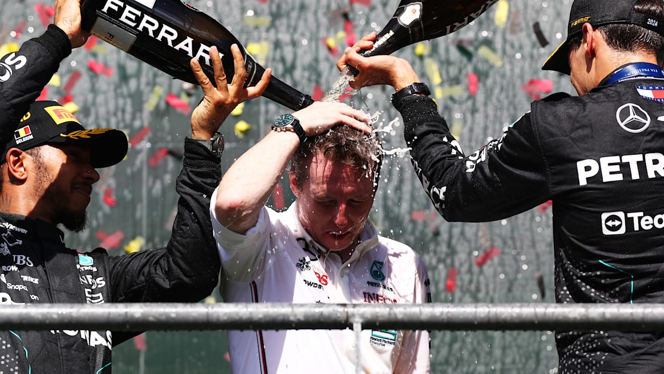 SPA, BELGIUM - JULY 28: Race winner George Russell of Great Britain and Mercedes (R), Second placed Lewis Hamilton of Great Britain and Mercedes (L) and Lead Race Stragegist of Mercedes (C) celebrate on the podium during the F1 Grand Prix of Belgium at Circuit de Spa-Francorchamps on July 28, 2024 in Spa, Belgium. (Photo by Peter Fox - Formula 1/Formula 1 via Getty Images)