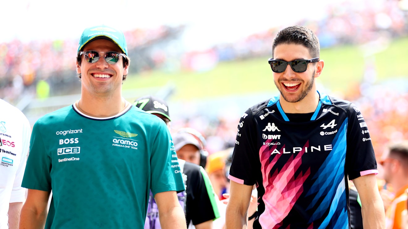 BUDAPEST, HUNGARY - JULY 21: Lance Stroll of Canada and Aston Martin F1 Team and Esteban Ocon of France and Alpine F1 talk on the drivers parade prior to the F1 Grand Prix of Hungary at Hungaroring on July 21, 2024 in Budapest, Hungary. (Photo by Bryn Lennon - Formula 1/Formula 1 via Getty Images)