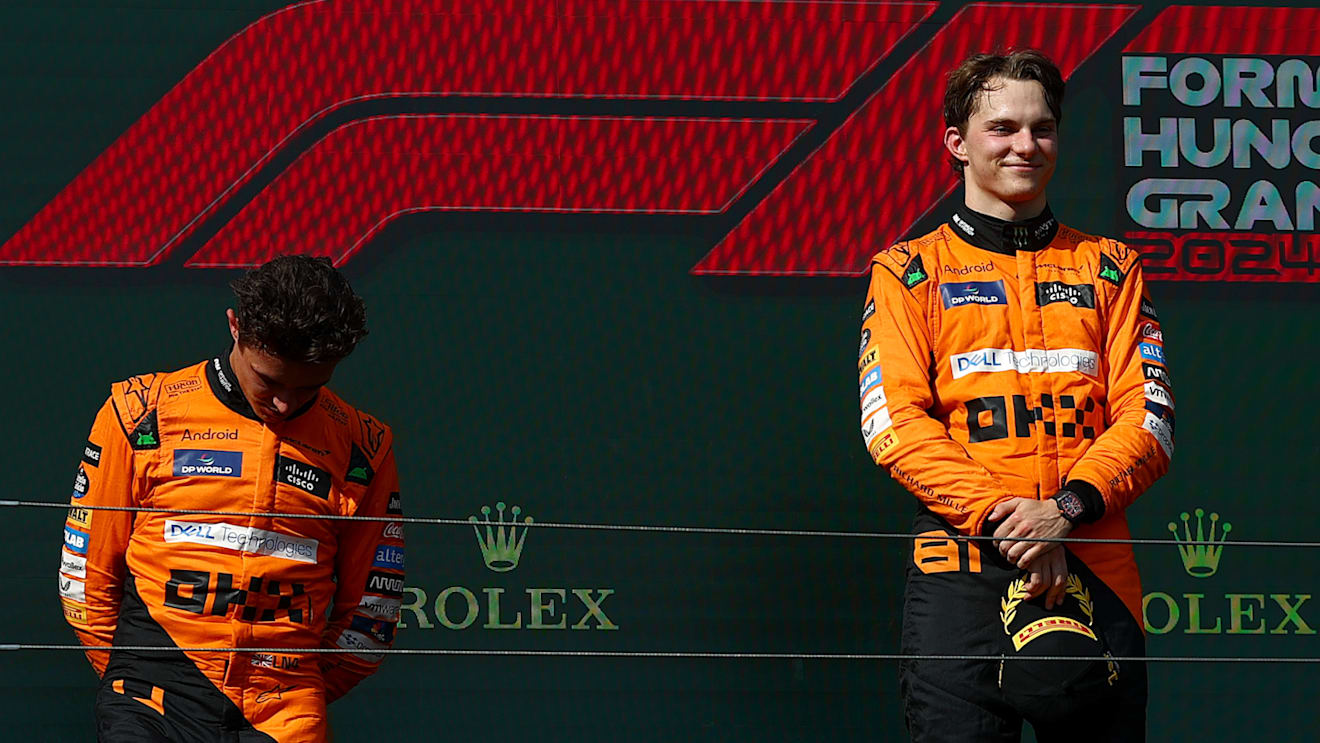 BUDAPEST, HUNGARY - JULY 21:Race winner Oscar Piastri of Australia and McLaren and Second placed Lando Norris of Great Britain and McLaren stand on the podium during the F1 Grand Prix of Hungary at Hungaroring on July 21, 2024 in Budapest, Hungary. (Photo by Joe Portlock - Formula 1/Formula 1 via Getty Images)