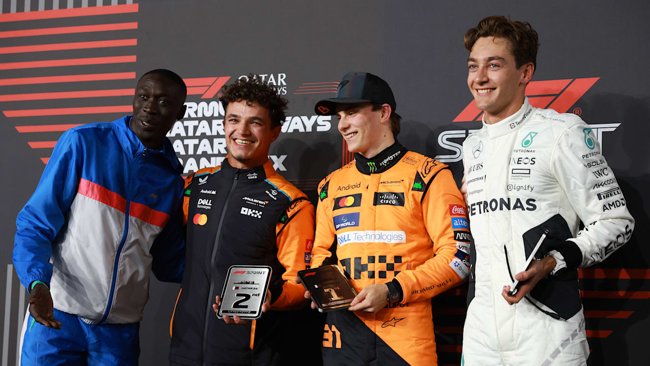 LUSAIL CITY, QATAR - NOVEMBER 30: Sprint winner Oscar Piastri of Australia and McLaren, Second placed Lando Norris of Great Britain and McLaren, Third placed George Russell of Great Britain and Mercedes and Khaby Lame pose for a photo in the Paddock during the Sprint ahead of the F1 Grand Prix of Qatar at Lusail International Circuit on November 30, 2024 in Lusail City, Qatar. (Photo by Bryn Lennon - Formula 1/Formula 1 via Getty Images)