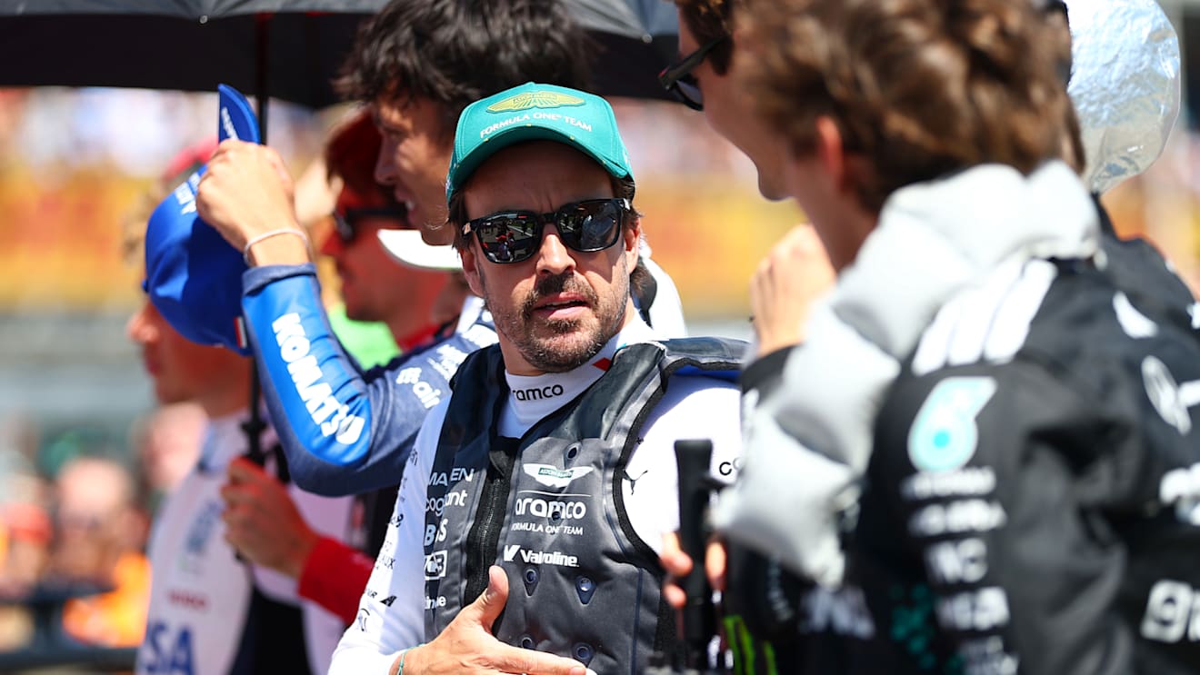 IMOLA, ITALY - MAY 18: Fernando Alonso of Spain and Aston Martin F1 Team and George Russell of Great Britain and Mercedes AMG Petronas F1 Team talk on the grid during the F1 Grand Prix of Emilia-Romagna at Autodromo Internazionale Enzo e Dino Ferrari on May 18, 2025 in Imola, Italy. (Photo by Bryn Lennon - Formula 1/Formula 1 via Getty Images)