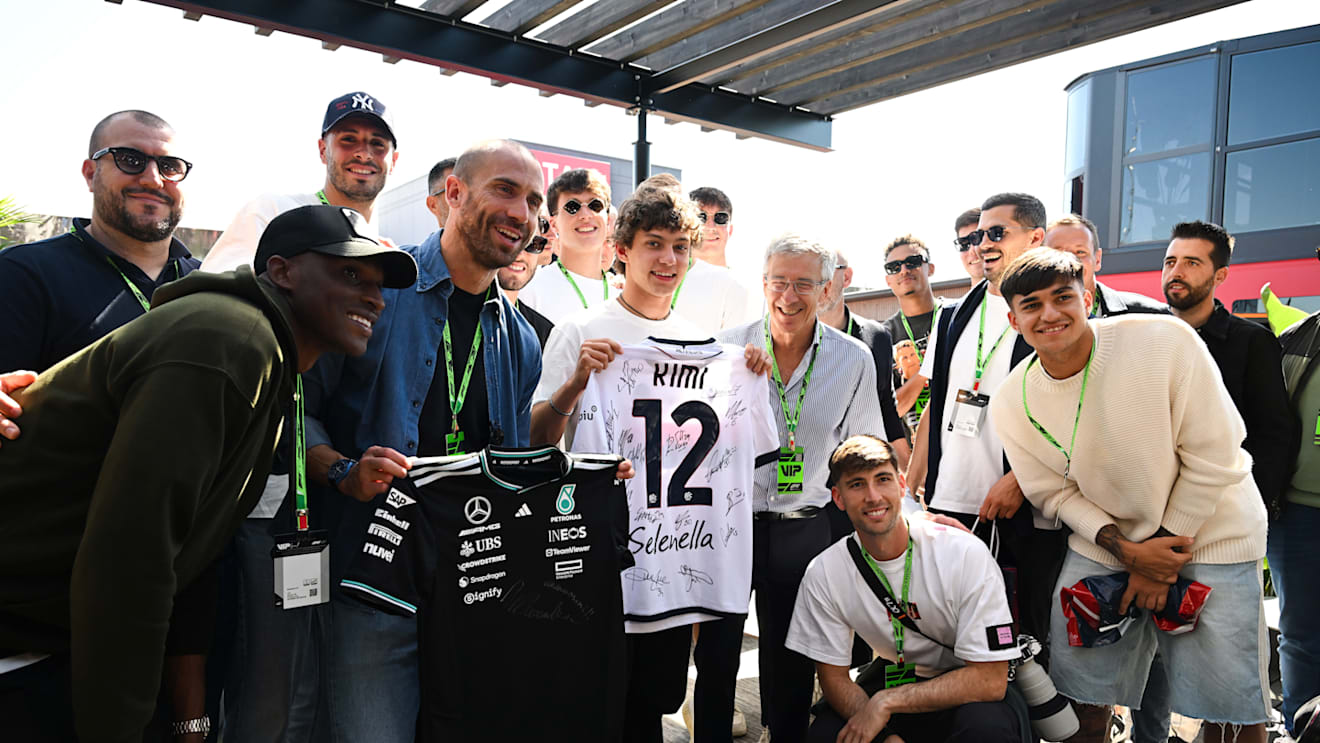 IMOLA, ITALY - MAY 16: Lorenzo De Silvestri of FC Bologna swaps shirts with Andrea Kimi Antonelli of Italy and Mercedes AMG Petronas F1 Team during practice ahead of the F1 Grand Prix of Emilia-Romagna at Autodromo Internazionale Enzo e Dino Ferrari on May 16, 2025 in Imola, Italy. (Photo by Mark Sutton - Formula 1/Formula 1 via Getty Images)