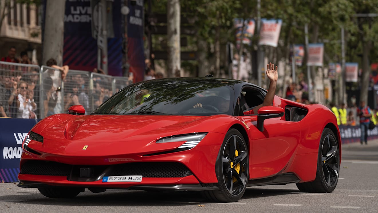Sainz waves to his home fans as he takes a spin in a Ferrari road car