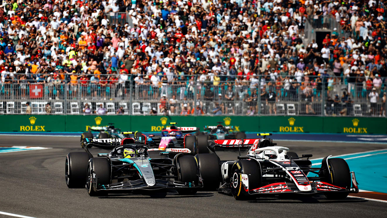 MIAMI, FLORIDA - MAY 05: Nico Hulkenberg of Germany driving the (27) Haas F1 VF-24 Ferrari and Lewis Hamilton of Great Britain driving the (44) Mercedes AMG Petronas F1 Team W15 battle for position on track during the F1 Grand Prix of Miami at Miami International Autodrome on May 05, 2024 in Miami, Florida. (Photo by Chris Graythen/Getty Images)