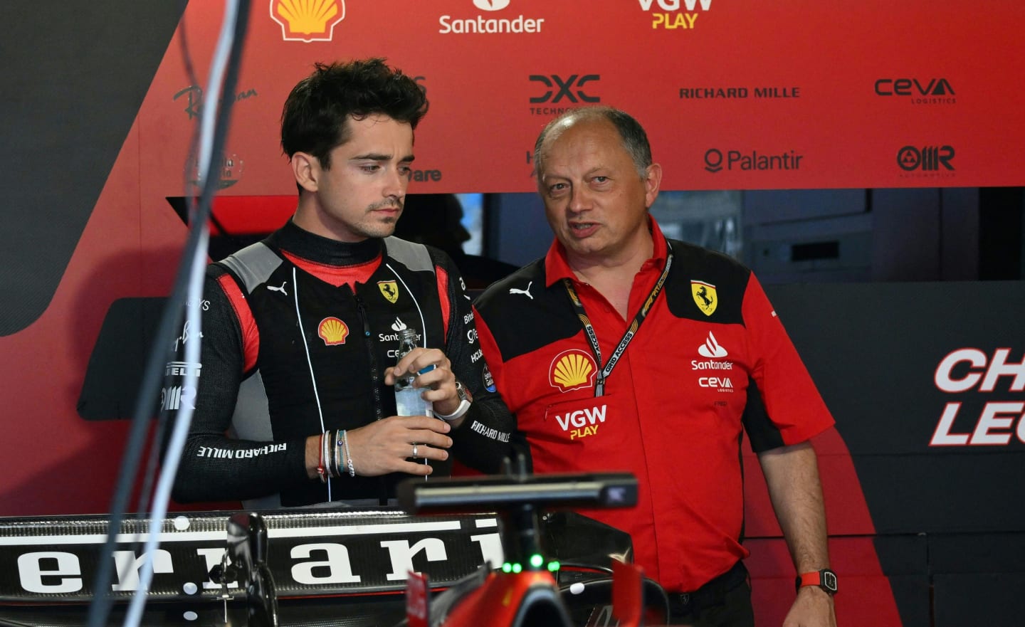 Ferrari's Monegasque driver Charles Leclerc (L) speaks with Ferrari's team principal Frederic